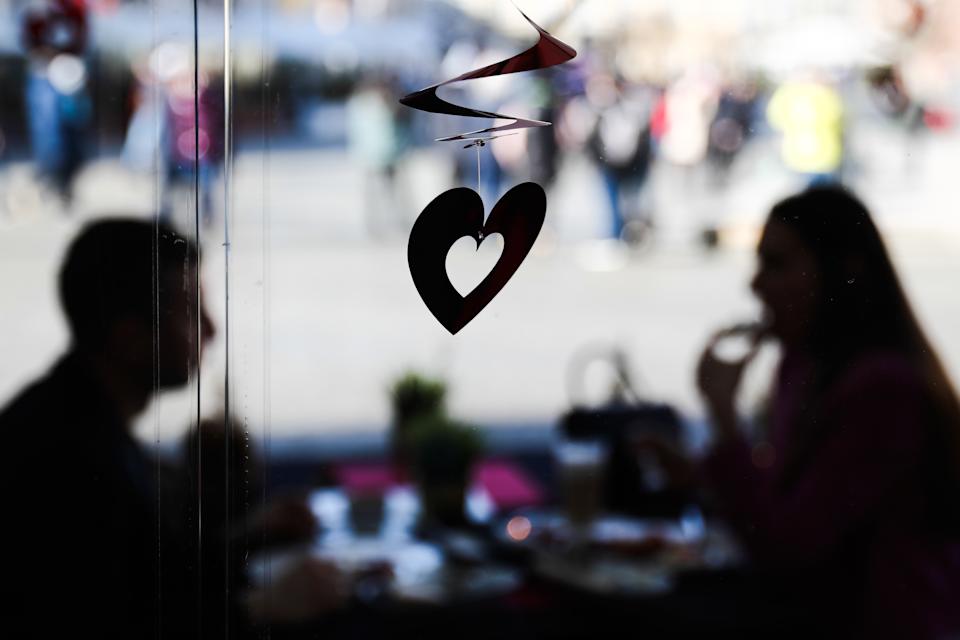 Dekoracja w kształcie serca i para siedząca przy stole w restauracji, dzień przed Walentynkami, Kraków 13 lutego 2022 (fot. Jacob Borzeki/Noor Photo via Getty Images)