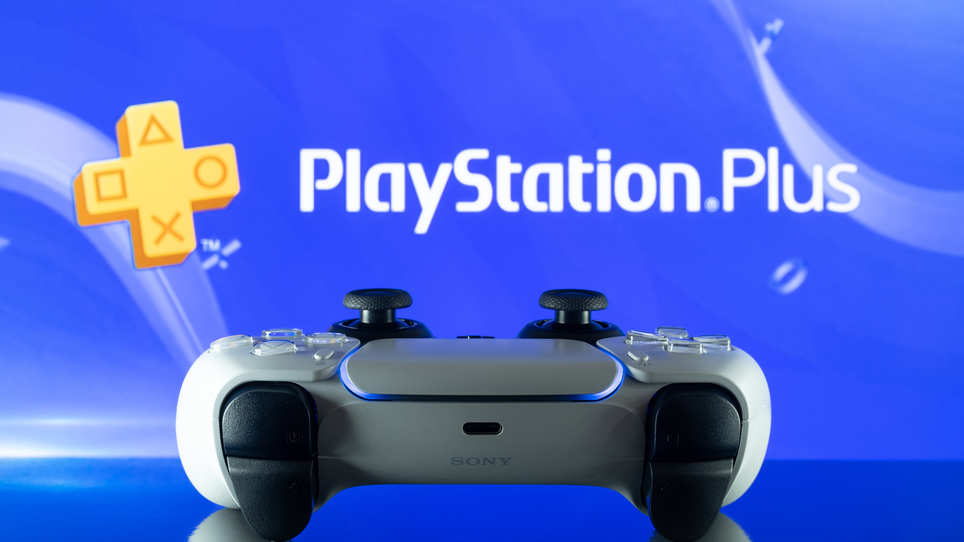 Kontroler DualSense PS5 przed logo PlayStation Plus