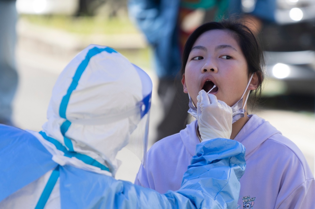 Dziewczynce pobiera się wymaz z ust w celu przeprowadzenia testu na COVID-19 w Szanghaju w Chinach 22 kwietnia 2022 r.