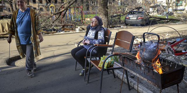 Miejscowe kobiety gromadzą się we wtorek 26 kwietnia przed wejściem do zniszczonego budynku mieszkalnego w Mariupolu na Ukrainie.