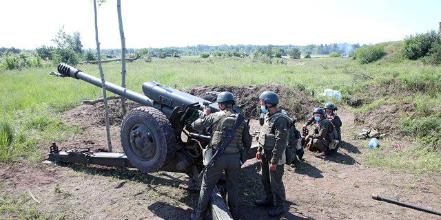 Żołnierze wyciągają haubice podczas ćwiczenia artyleryjskiego wschodniego Dowództwa Operacyjnego Gwardii Narodowej Ukrainy, obwód charkowski, północno-wschodnia Ukraina. 