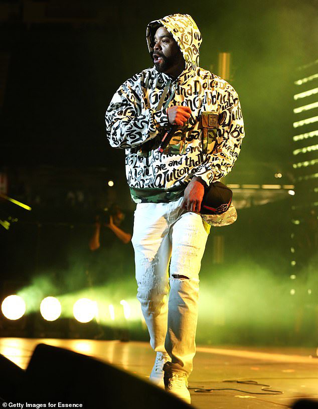Skomplikowane: styl nosi białą bluzę z kapturem pokrytą czarnym tekstem podczas solowego spotu na scenie