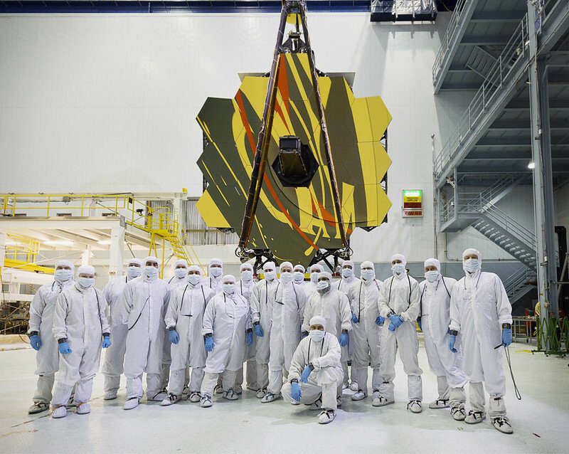 Naukowcy stojący przed Kosmicznym Teleskopem Jamesa Webba