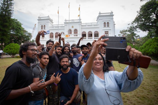 Protestujący pozują do grupowego selfie podczas oddawania Kancelarii Premiera władzom rządowym.