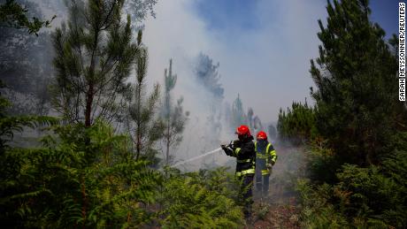 Strażacy pracują nad powstrzymaniem pożaru w pobliżu Louchats we Francji, gdzie krajowa agencja meteorologiczna ogłasza ostrzeżenia o rosnących temperaturach. 
