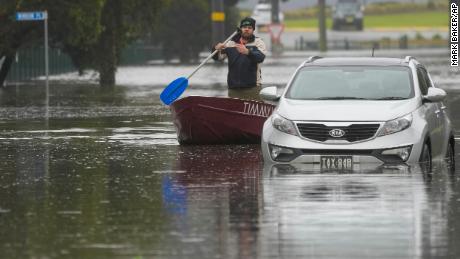 Mężczyzna pływa łodzią po zalanej ulicy w Windsor na obrzeżach Sydney w Australii, 5 lipca 2022 r.