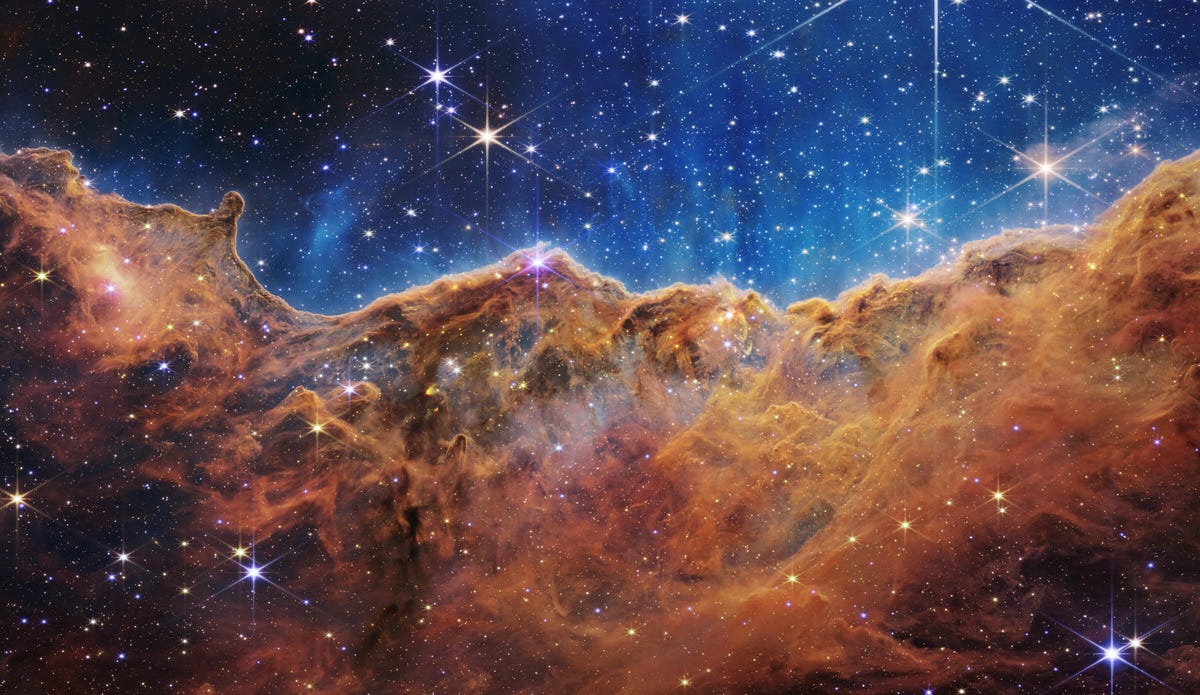Mgławica Carina: Gwiazdy błyszczą na tle indygo nad chmurami gazu w kolorze rdzawego brązu