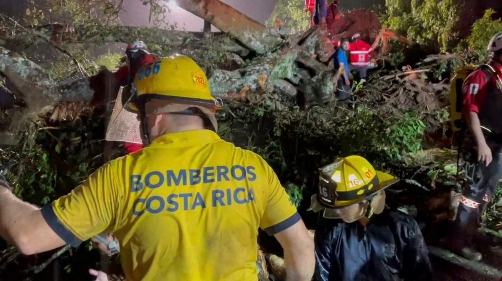 Strażacy są widziani, gdy osuwisko uderza w samochód w Cambronero, prowincja Alajuela, Kostaryka, 17 września 2022 r.