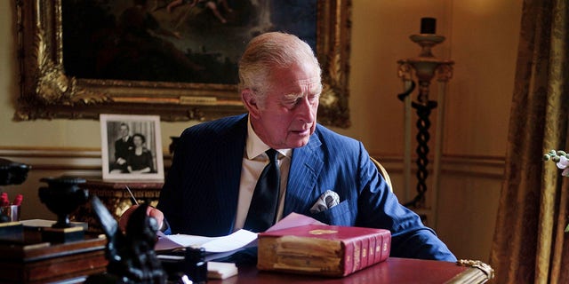 Na tym zdjęciu z 11 września 2022 r. brytyjski król Karol III wykonuje oficjalne obowiązki rządowe ze swojej czerwonej skrzyni w XVIII-wiecznym pokoju w Pałacu Buckingham w Londynie.  (Victoria Jones/PA przez AP)