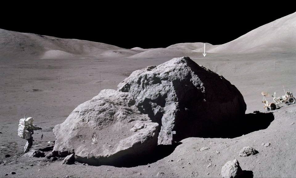 Czas na powierzchni Apollo 17, najdłużej trwającego programu na Księżycu, wynosił trzy dni, dwie godziny i pięćdziesiąt dziewięć minut.  Zdjęcie przedstawia Jacka Schmidta ze statku kosmicznego Apollo 17, niosącego skorpiona z powrotem w kierunku modułu księżycowego po zaobserwowaniu i pobraniu próbek ze wschodniej strony masywnego głazu.  Pionowa strzałka na odległości wskazuje na moduł Lunar Module Challenger, znajdujący się około 2 mile (3,1 km).