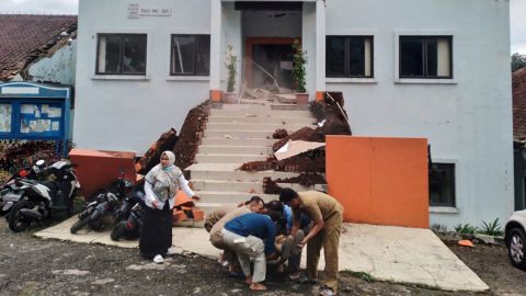 Funkcjonariusze miejscy w Cianjur ewakuują rannego kolegę po trzęsieniu ziemi.