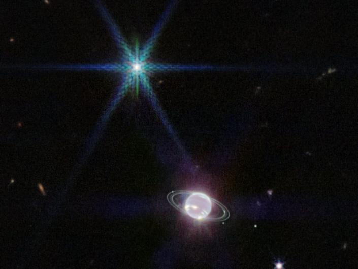 Kamera internetowa bliskiej podczerwieni (NIRCam) przedstawiająca Neptuna i jego pierścienie.  Neptun ma 14 znanych satelitów, a na tym zdjęciu widocznych jest siedem z nich.