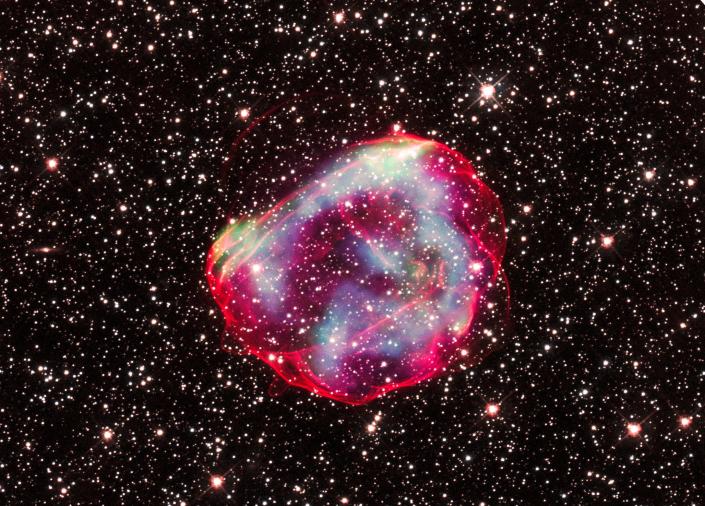 Pozostałość po supernowej błyszczącej różowej bańki na tle gwiazd