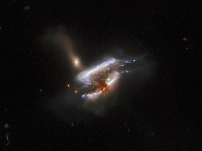 Trzy splecione galaktyki łączą się w czarnej przestrzeni