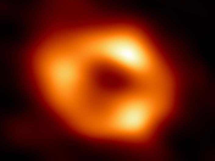 obraz czarnej dziury przedstawiający pomarańczowy pierścień Strzelca A*